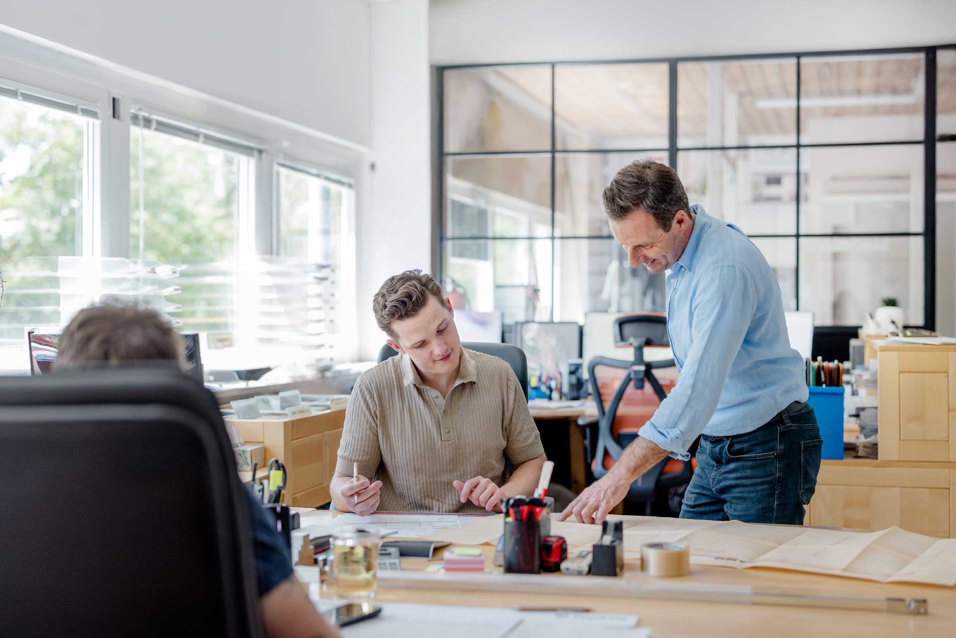 Team arbeitet gemeinsam an Schreibtischen im Büro