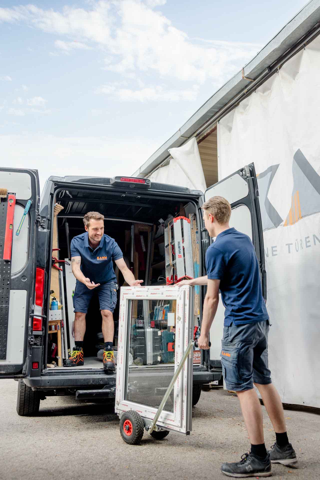 Mitarbeiter beim Verladen eines Fensters in den Lieferwagen