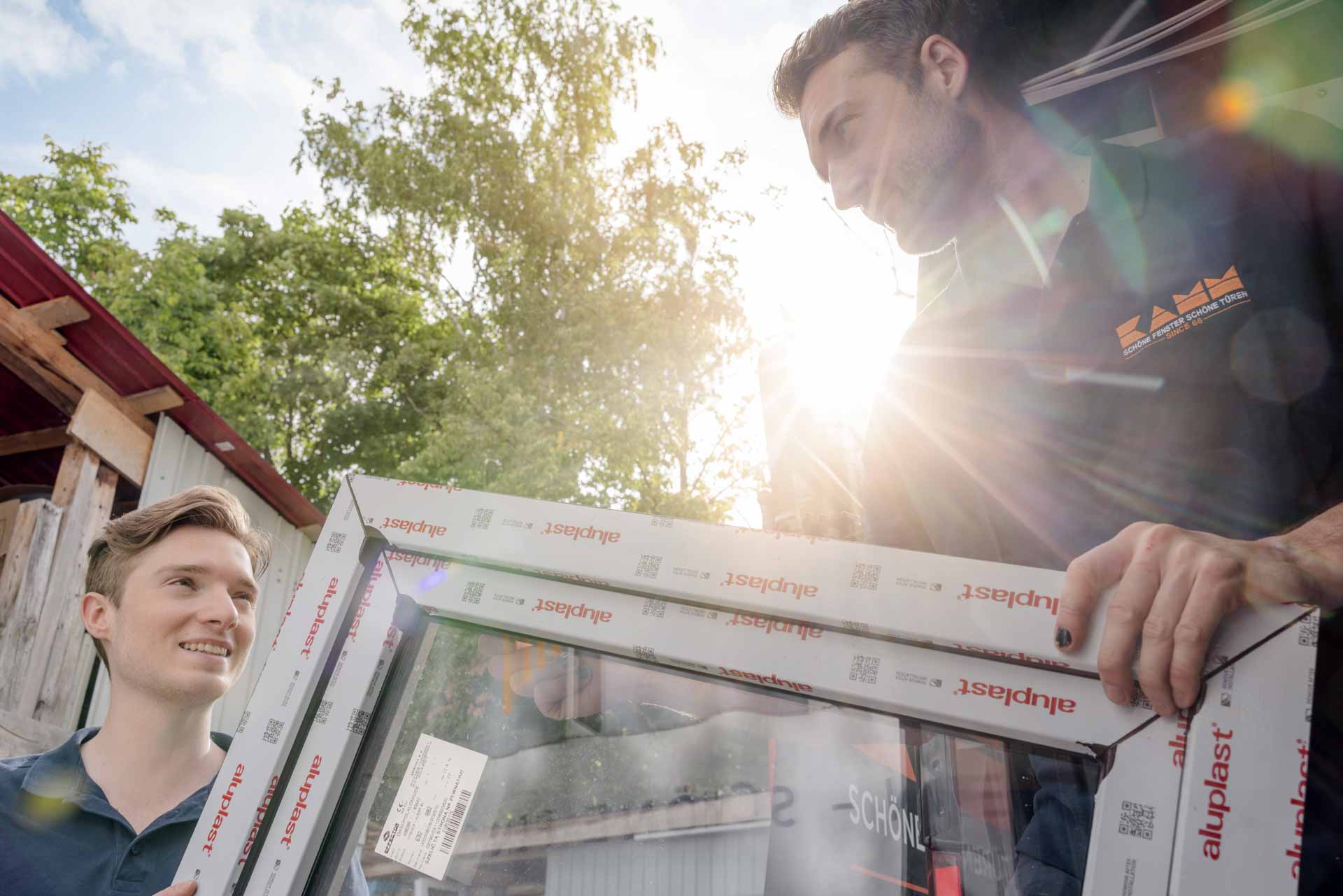 Mitarbeiter beim Verladen eines Fensters in den Lieferwagen