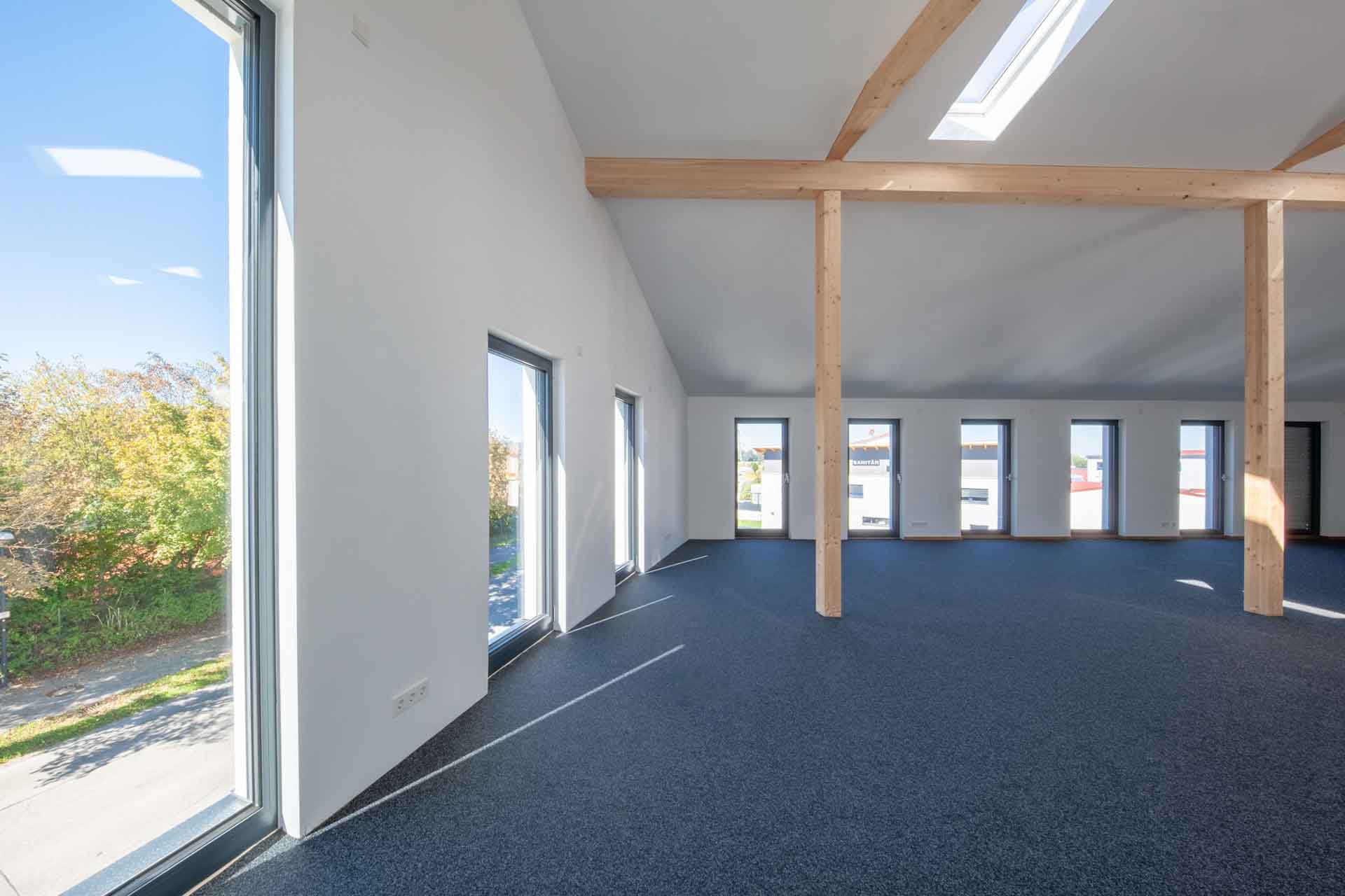 Großer Raum mit Aluminium Fenster und Holzbalken in Germering.
