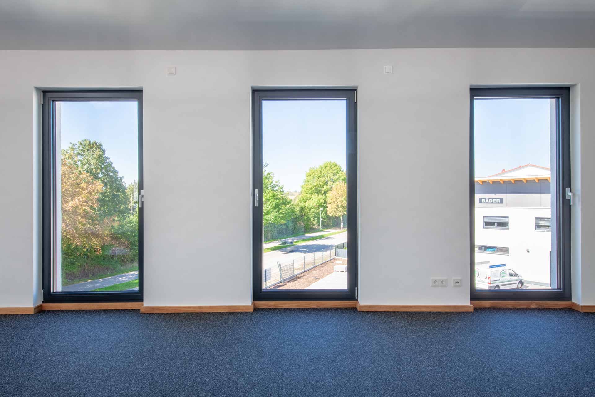 Drei schmale, hohe Aluminium Fenster in dunklem Rahmen in Grrmering.