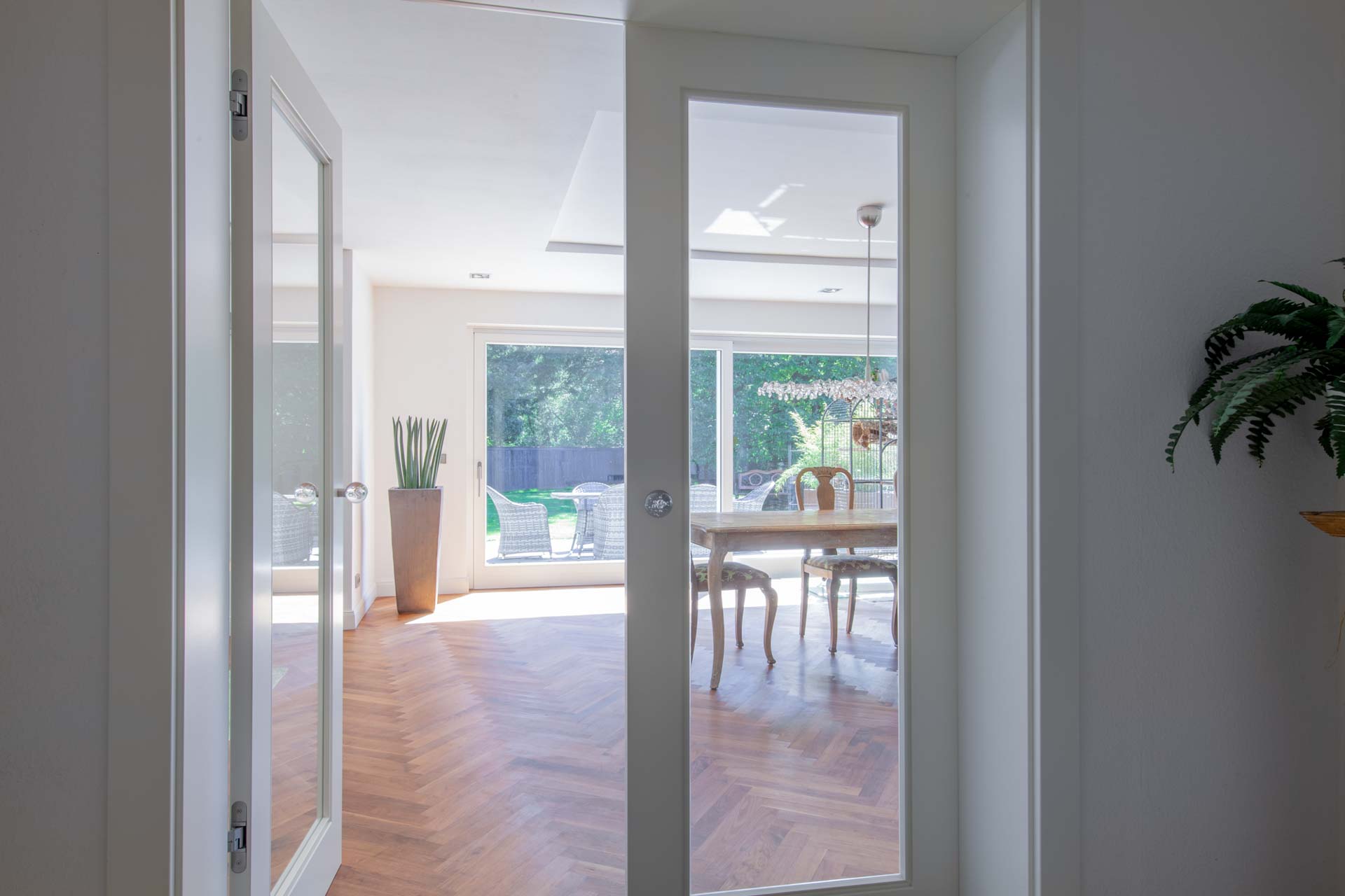 Weiße Innentür aus Glas mit Holzboden im Wohnraum in Germering.