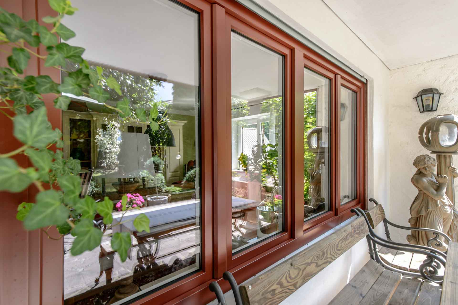 Mehrteiliges Fenster mit braunem Rahmen und Verglasung für die Terrasse.