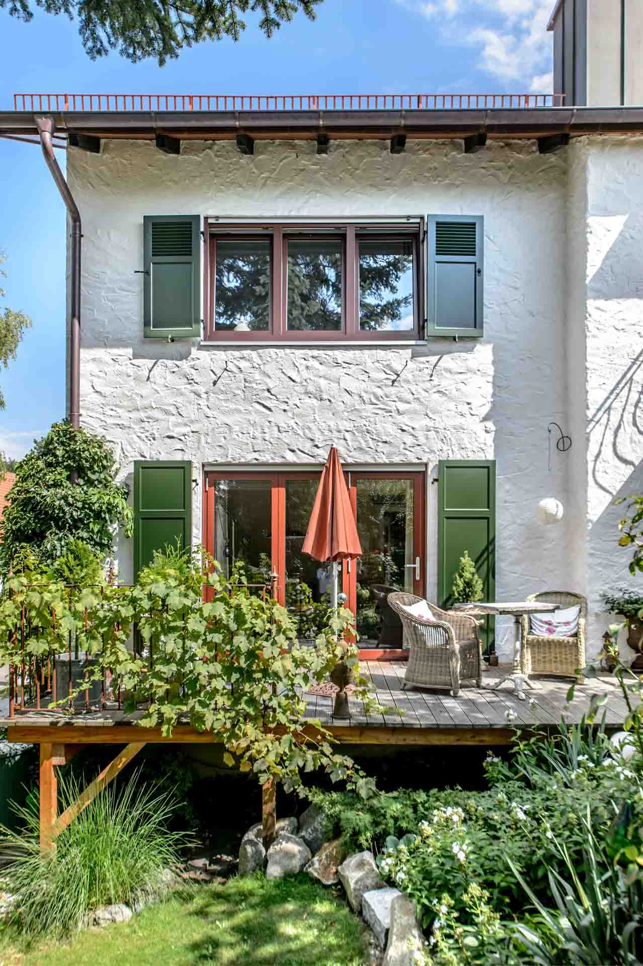 Fenster und Terrassentür mit rotem Rahmen und grünen Fensterläden in Haag an der Amper.