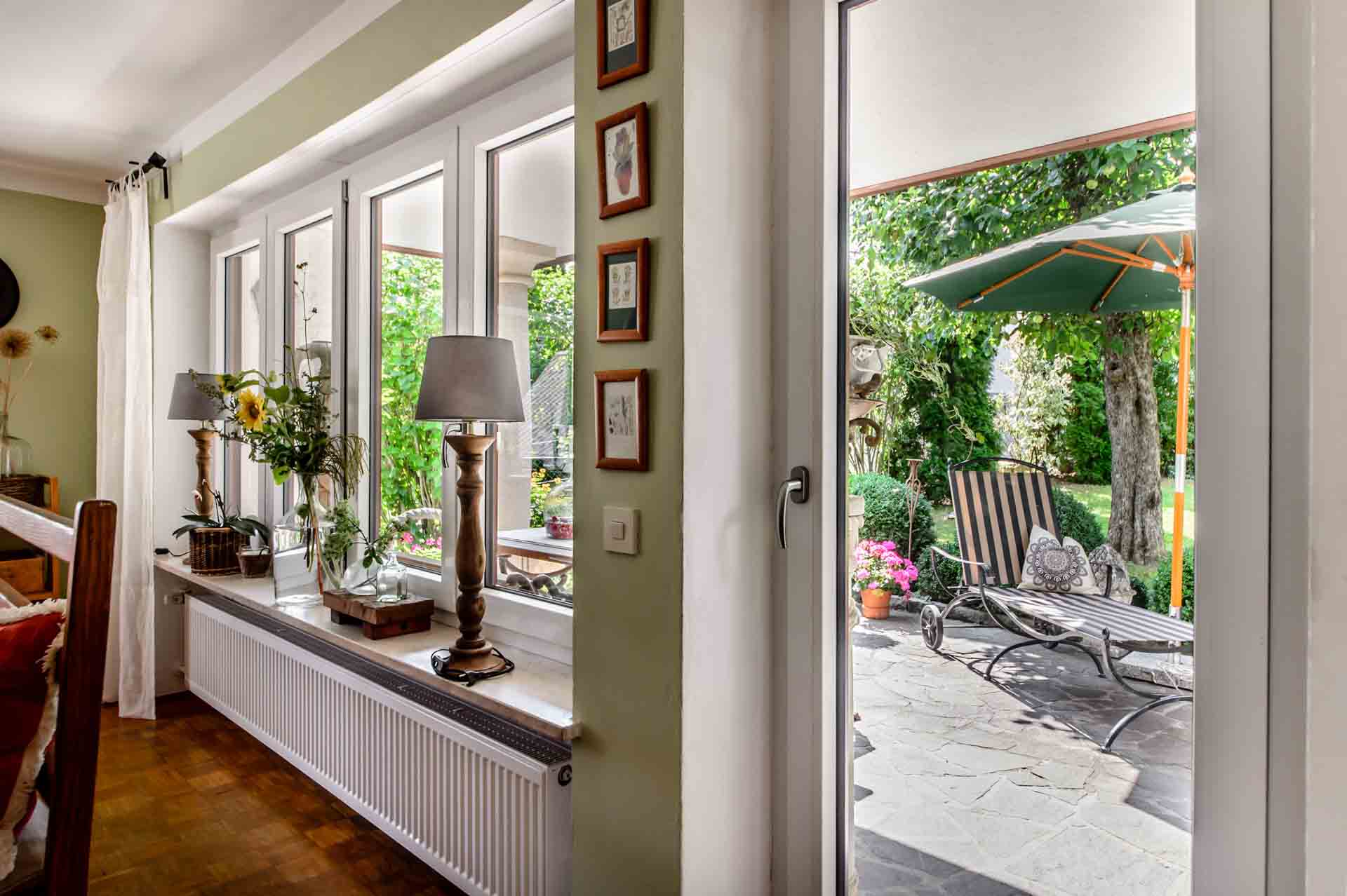 Terrassentür neben einer langen Fensterbank mit Heizkörper.