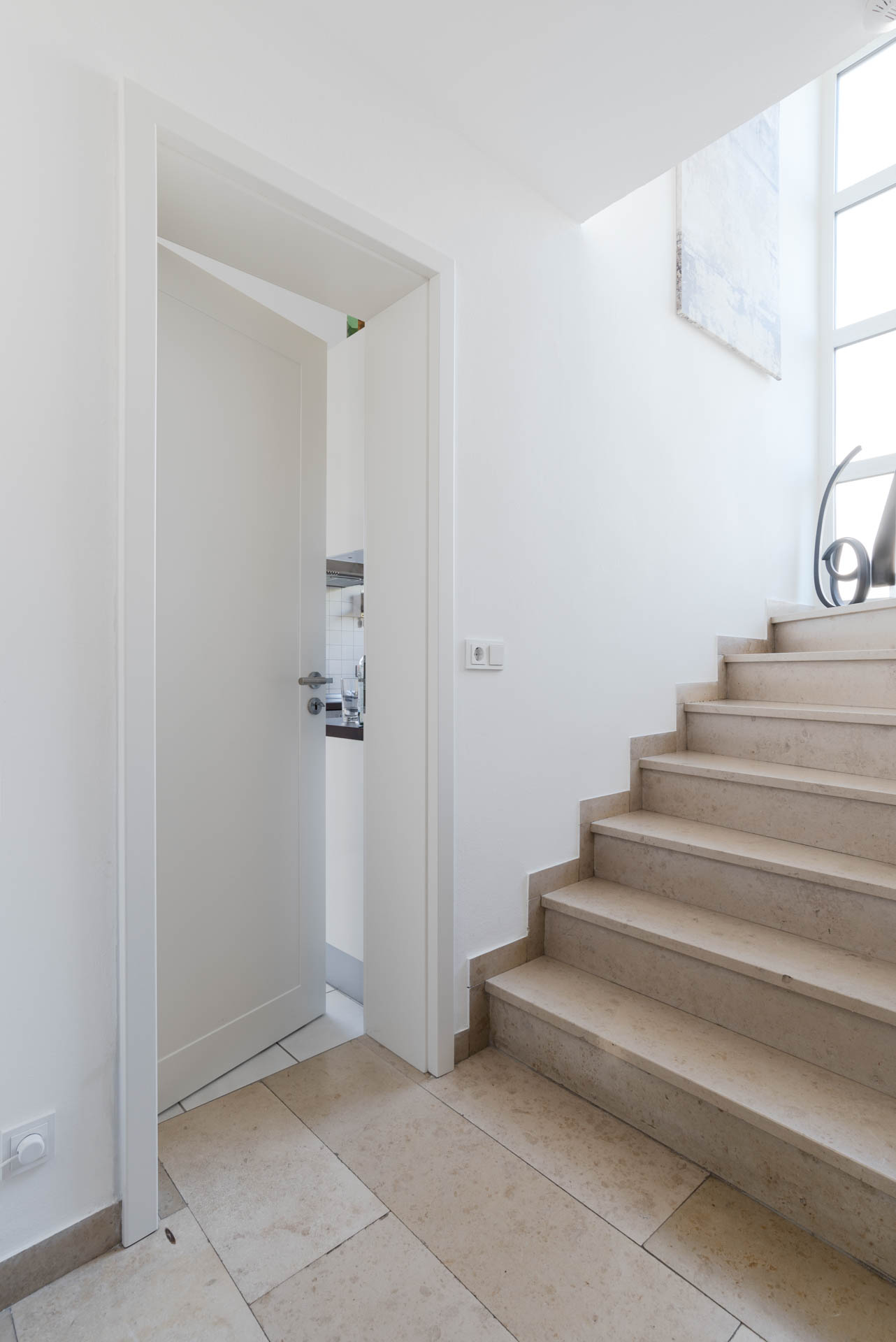 Schlichte, weiße Innentür am Treppenaufgang.