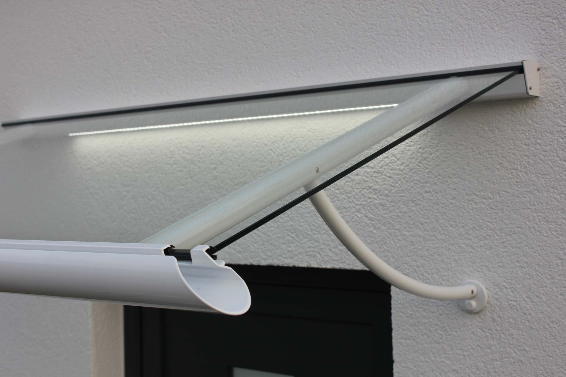 Elegantes, weißes Vordach mit gebogenen Haltearmen und integrierter LED-Beleuchtung.