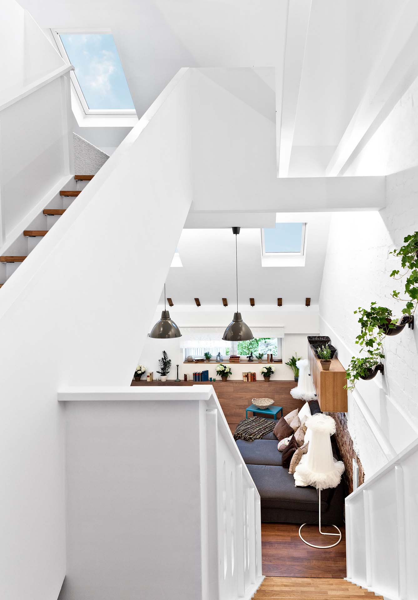 Hohes, modernes Treppenhaus mit mehreren Dachfenstern, die den Innenraum natürlich mit Licht versorgen.