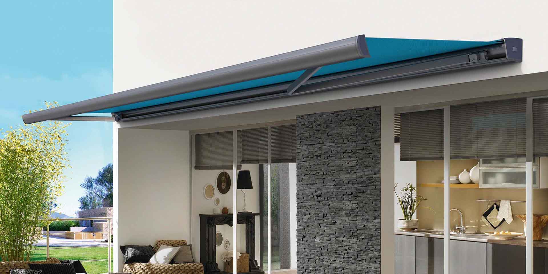 Halb geöffnete Kassettenmarkise in Anthrazit mit blauem Tuch über der Terrasse einer modernen Wohnung.