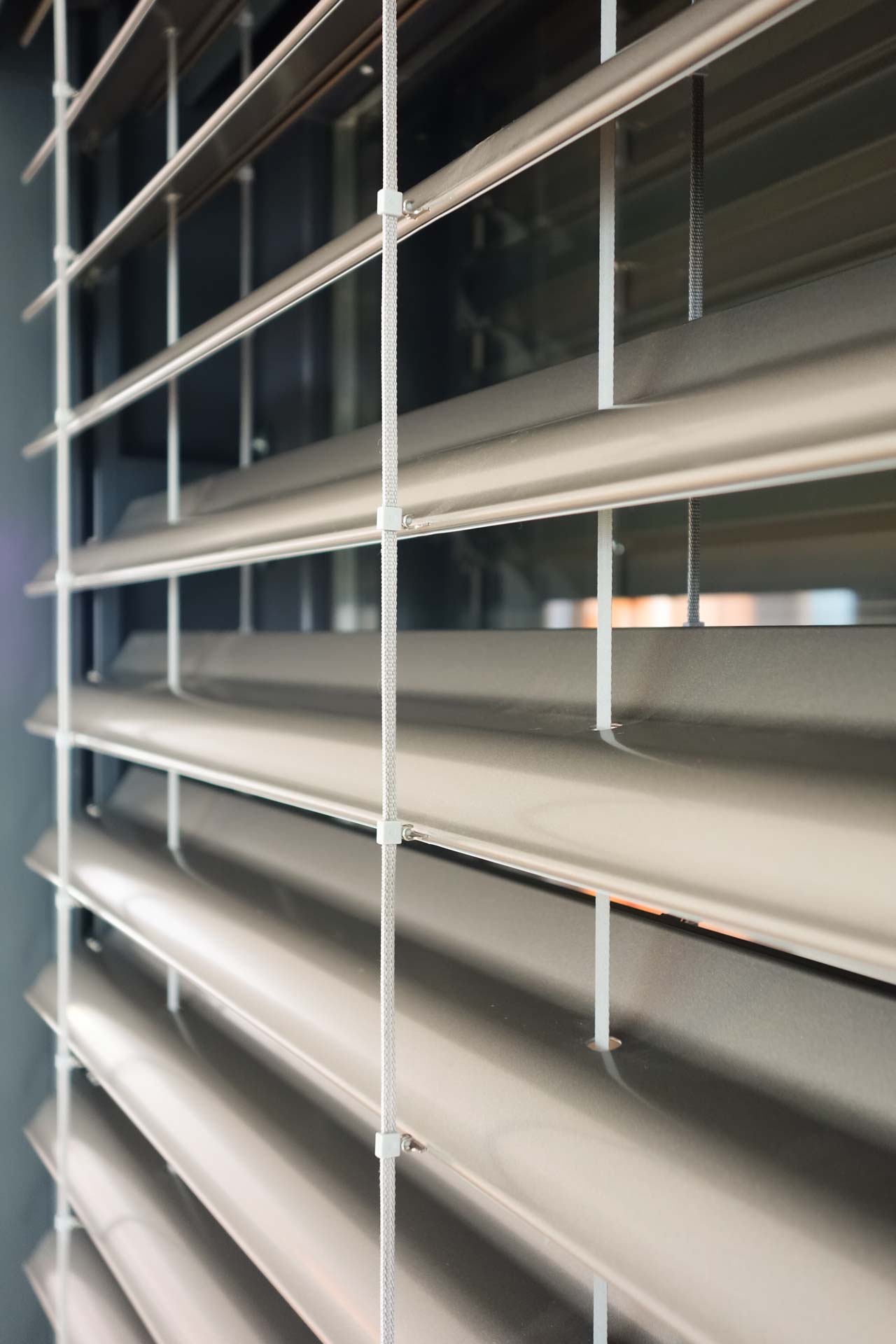 Nahaufnahme der horizontalen Lamellen eines Raffstore- oder Sonnenschutz-Systems in Metallic-Optik.